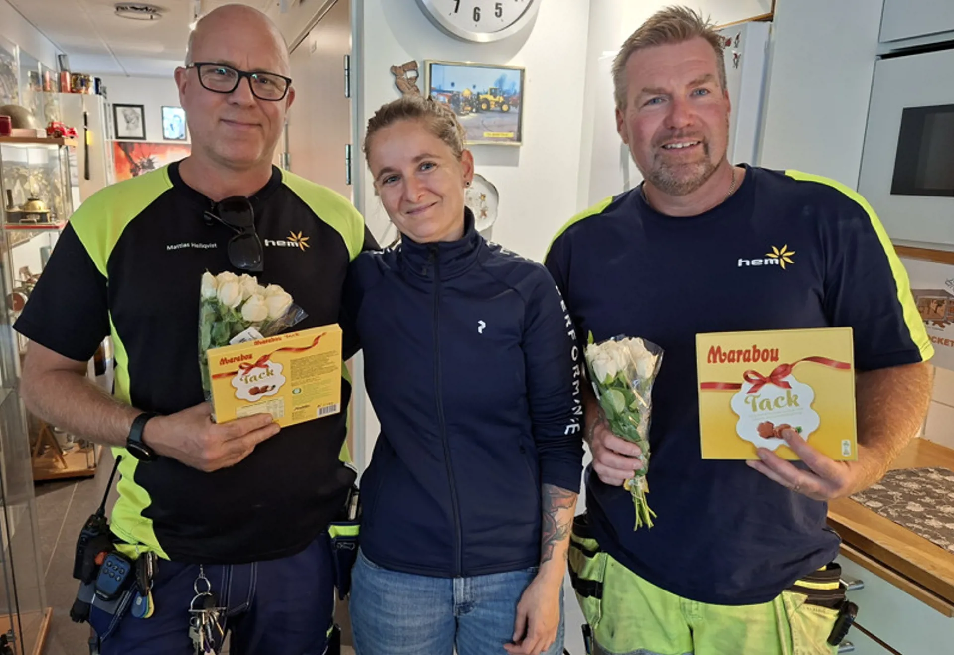 Anja Andreasson står med en blombukett tillsammans med två medarbetare i personalrummet på återvinningscentralen.